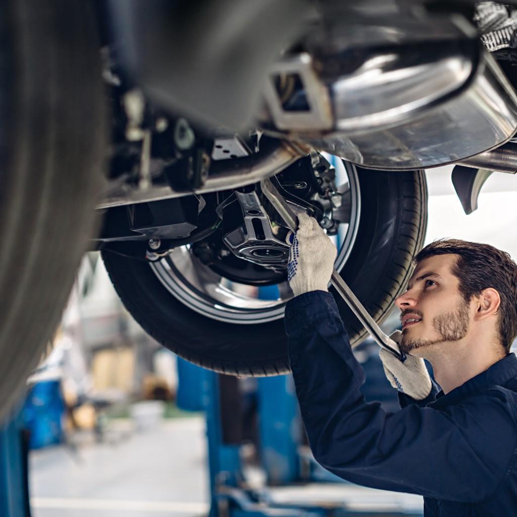 Mechanic working under a car on a lift