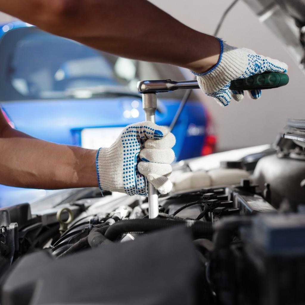 Mechanic using a ratchet on an engine
