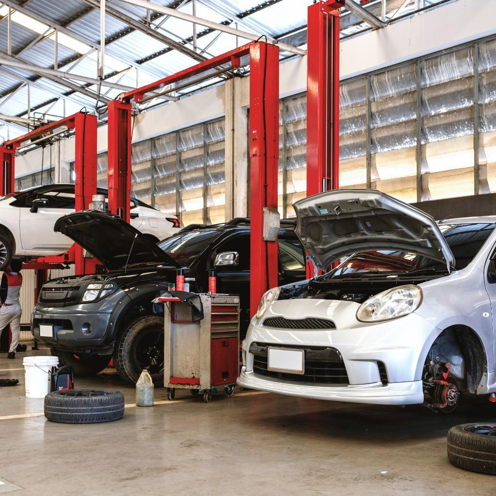 Cars in workshop bays with bonnets open