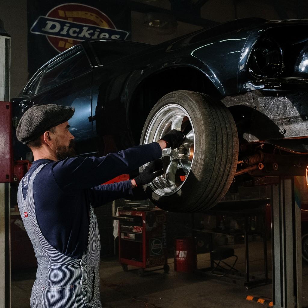 Mechanic fitting a wheel in the workshop
